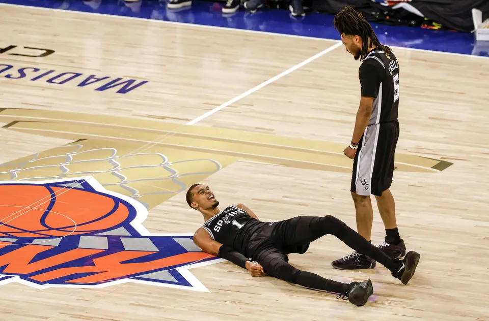 San Antonio Spurs guard Stephon Castle (5) goes over to help a wincing Spurs center Victor Wembanyama (1) after falling on his back during the fourth quarter of Game 3 of the NBA Finals at Madison Square Garden in New York, Monday, June 8, 2026. The Spurs defeated the Knicks 115-111.