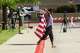 Jasmine Noelle walks around draped in an American flag outside of the Collin County Courthouse as closing arguments are scheduled to start in Karmelo Anthony’s murder trial in McKinney, TX, Tuesday, June 9, 2026. Anthony is accused of killing 17-year-old Austin Metcalf last April at a Frisco track meet at David Kuykendall Stadium.
