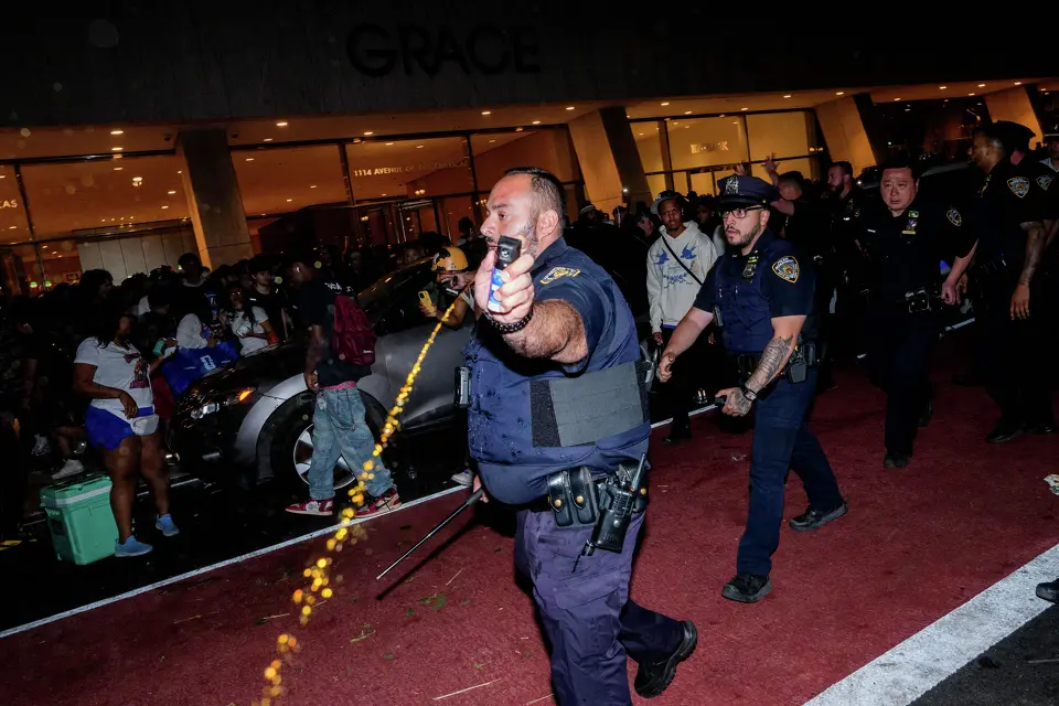 An NYPD officer uses pepper spray as New York Knicks fans clash with NYPD officers outside of a watch party at Bryant Park for Game 3 of the NBA Finals between New York Knicks and San Antonio Spurs on June 8, 2026 in New York City. The New York City Police Department and Secret Service cancelled an NBA Finals watch party near Madison Square Garden, with fans advised to arrive at least two hours before Monday's game due to heightened security for U.S. President Donald Trump's attendance.