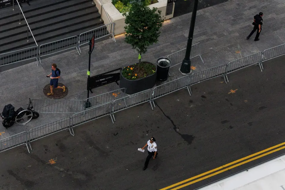 People walk by fencing put up by New York police officers to block of the intersections around Madison Square Garden in New York, Wednesday, June 10, 2026, before Game 4 of the NBA Finals between the San Antonio Spurs and the New York Knicks.