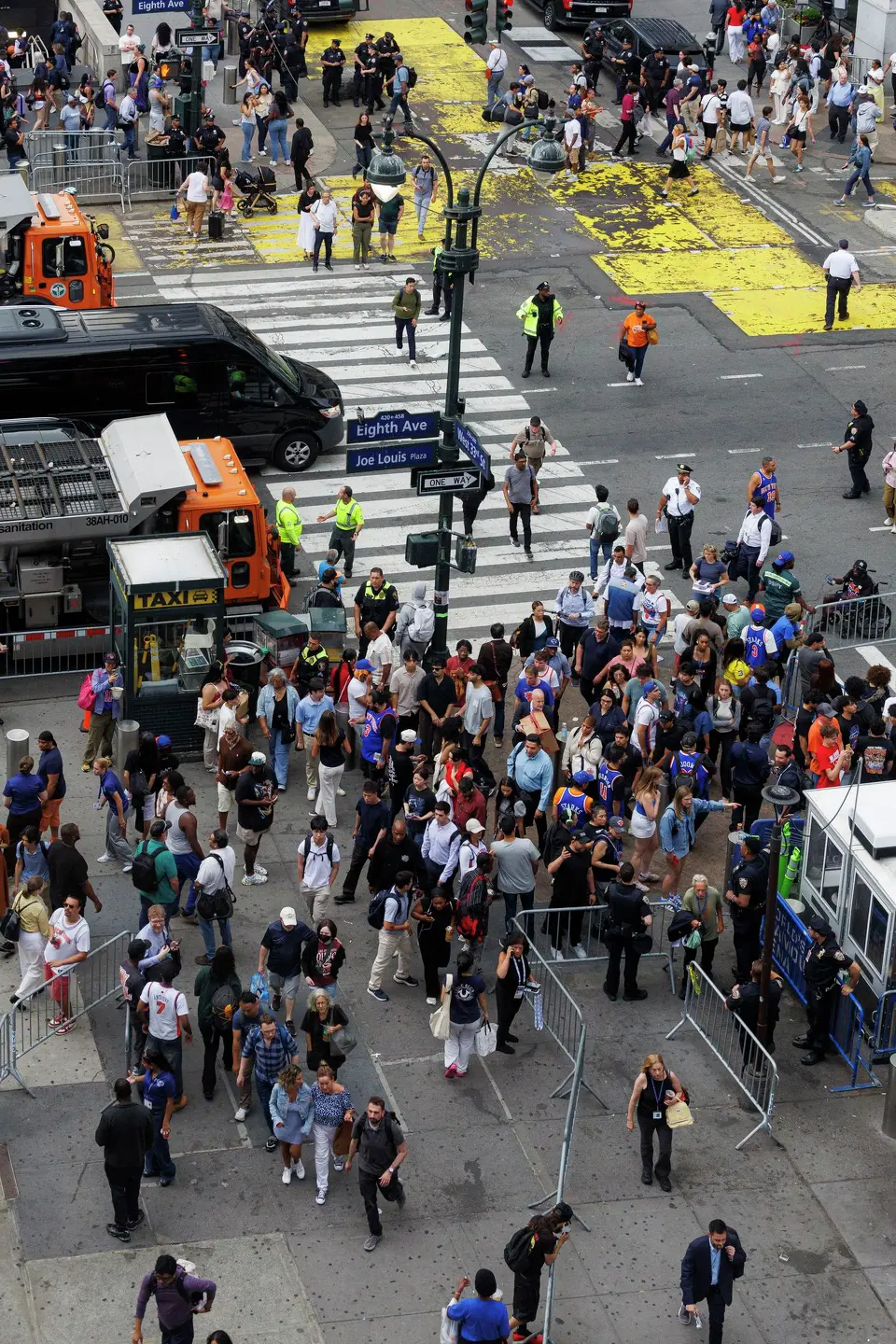 People walk by fencing put up by New York police officers to block of the intersections around Madison Square Garden in New York, Wednesday, June 10, 2026, before Game 4 of the NBA Finals between the San Antonio Spurs and the New York Knicks.