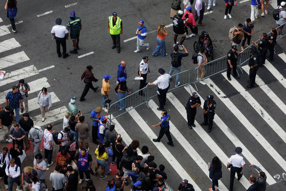 People walk by fencing put up by New York police officers to block of the intersections around Madison Square Garden in New York, Wednesday, June 10, 2026, before Game 4 of the NBA Finals between the San Antonio Spurs and the New York Knicks.