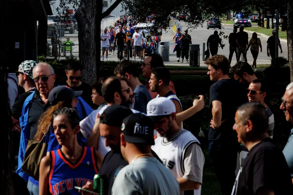 People walk towards the entrance of Frost Bank Center in San Antonio, Saturday, June 13, 2026, to attend Game 5 of the NBA Finals between the New York Knicks and the San Antonio Spurs.