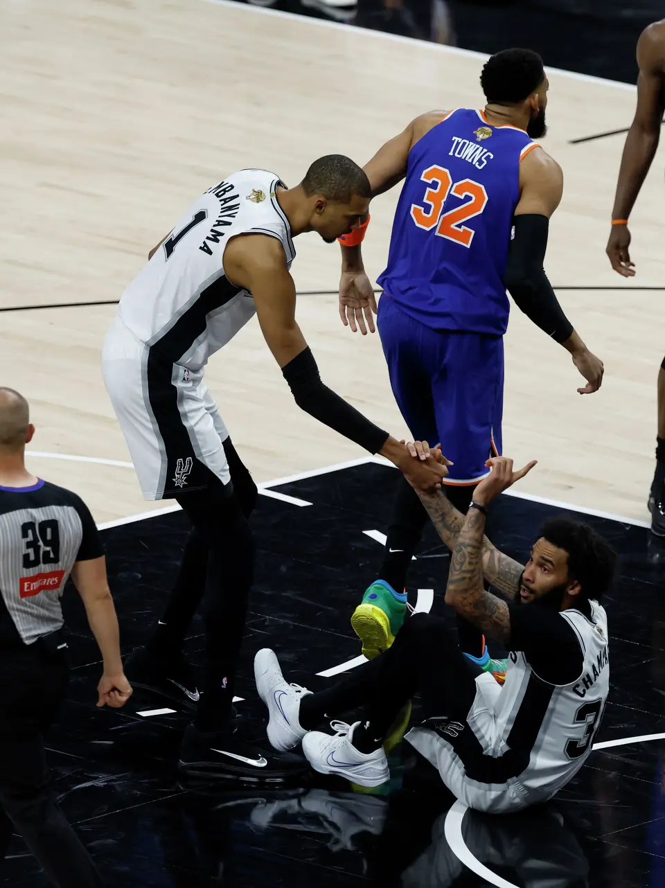 San Antonio Spurs forward Julian Champagnie (30) is helped up by San Antonio Spurs center Victor Wembanyama (1) after drawing a foul during the first quarter of game five of the NBA Championship at Frost Bank Center on Saturday, June13, 2026.