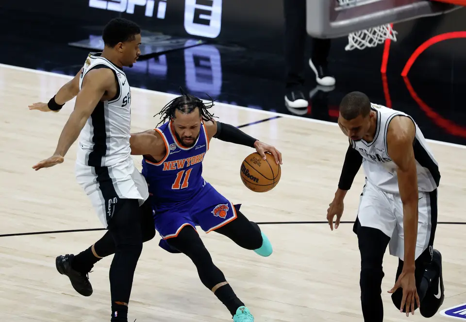 New York Knicks guard Jalen Brunson (11) bumps San Antonio Spurs forward Keldon Johnson (3) while driving towards the paint in the first quarter of game five of the NBA Championship at Frost Bank Center on Saturday, June13, 2026.