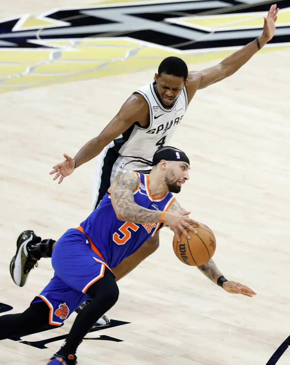 San Antonio Spurs guard De'Aaron Fox (4) draws a foul against New York Knicks guard Jose Alvarado (5) during the first quarter of game five of the NBA Championship at Frost Bank Center on Saturday, June13, 2026.