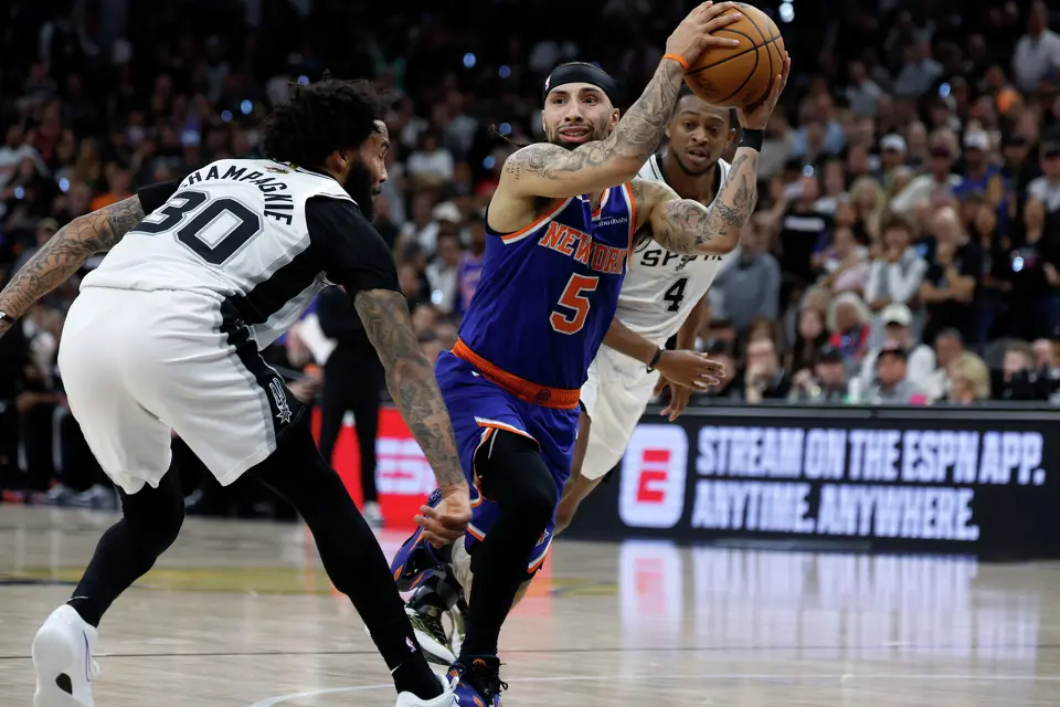 New York Knicks guard Jose Alvarado (5) passes the ball off past San Antonio Spurs forward Julian Champagnie (30) during the second quarter of game five of the NBA Championship at Frost Bank Center on Saturday, June13, 2026.