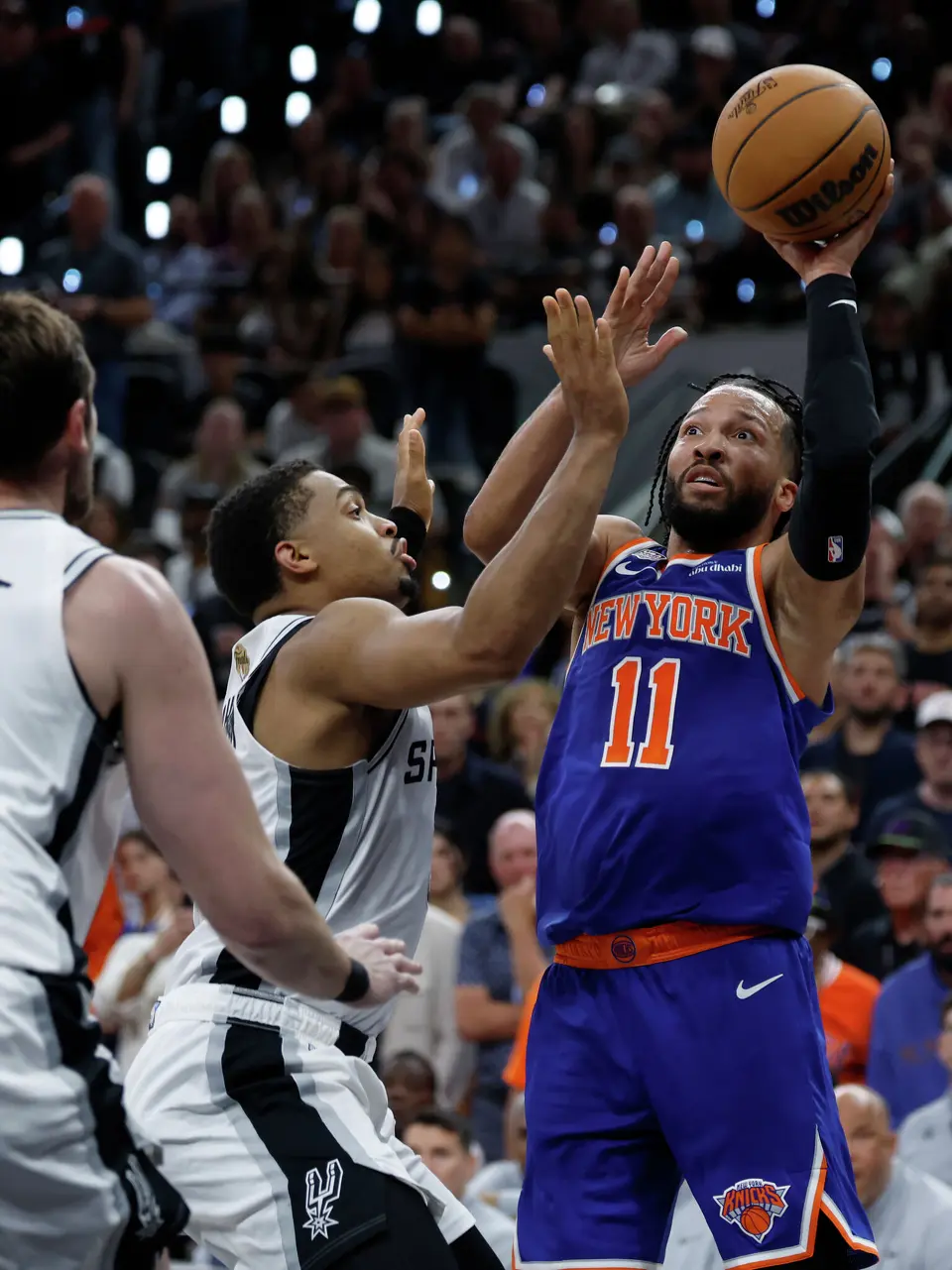New York Knicks guard Jalen Brunson (11) takes a jump shot while being guarded by San Antonio Spurs forward Keldon Johnson (3) during the second quarter of game five of the NBA Championship at Frost Bank Center on Saturday, June13, 2026.