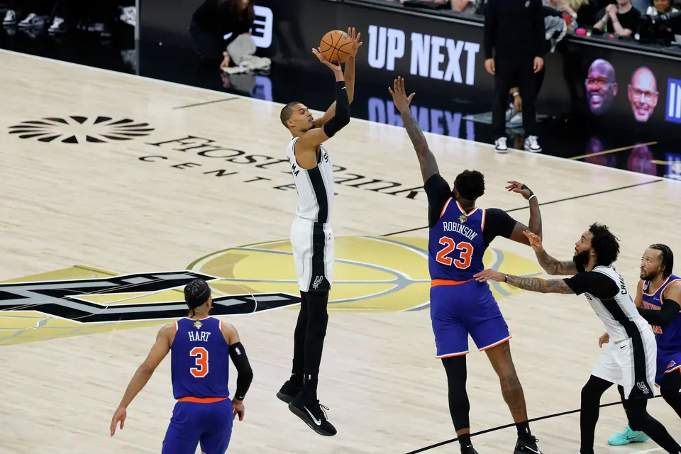 San Antonio Spurs center Victor Wembanyama (1) shoots a three point shot over New York Knicks center Mitchell Robinson (23) during the third quarter of game five of the NBA Championship at Frost Bank Center on Saturday, June13, 2026.