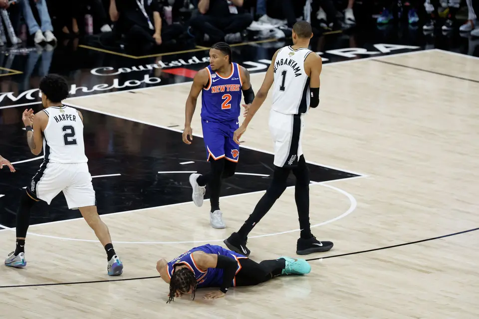 New York Knicks guard Jalen Brunson (11) falls to the floor as San Antonio Spurs center Victor Wembanyama (1)during the third quarter of game five of the NBA Championship at Frost Bank Center on Saturday, June13, 2026.