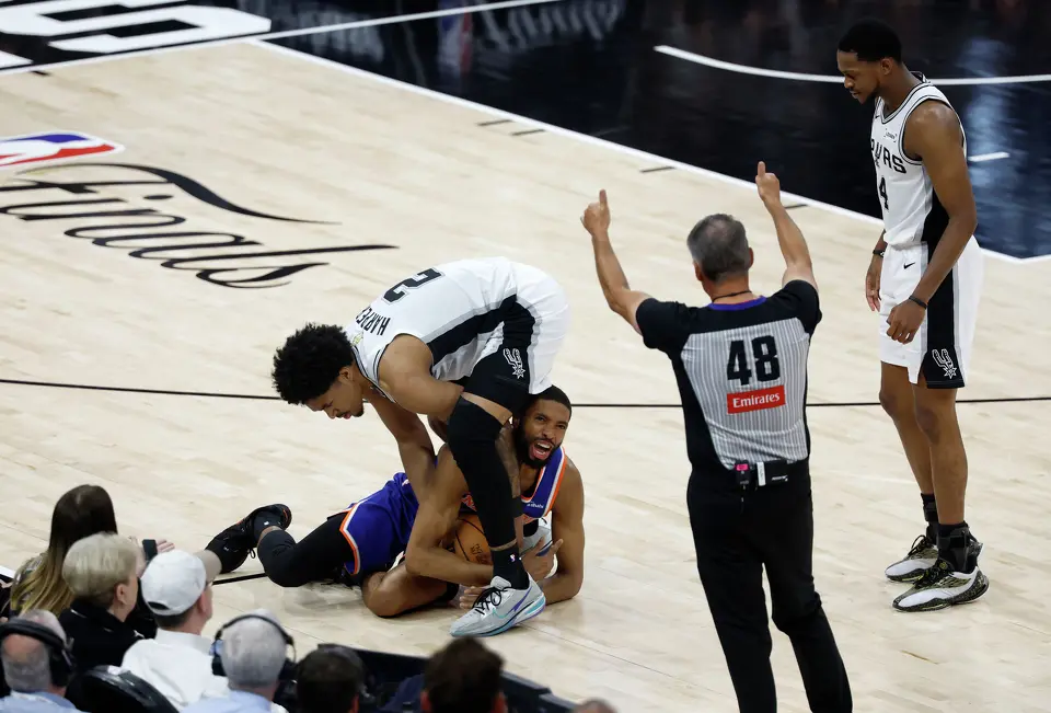 Referee Scott Foster (48) calls for a jump between New York Knicks guard Mikal Bridges (25) and San Antonio Spurs guard Dylan Harper (2) during the third quarter of game five of the NBA Championship at Frost Bank Center on Saturday, June13, 2026.