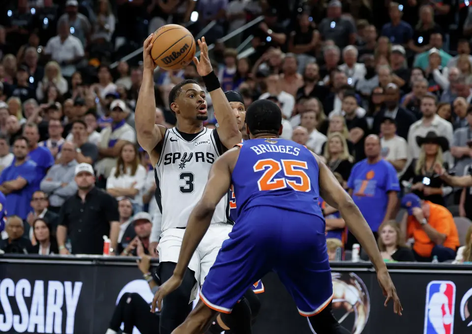 San Antonio Spurs forward Keldon Johnson (3) looks for an open man while being guarded by New York Knicks guard Mikal Bridges (25) during the fourth quarter of game five of the NBA Championship at Frost Bank Center on Saturday, June13, 2026.