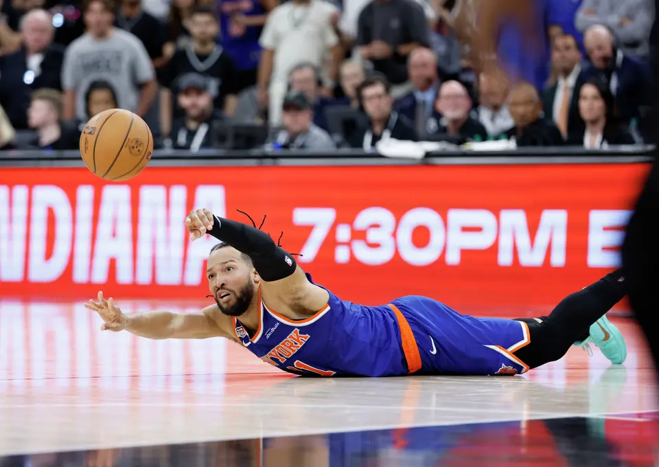 New York Knicks guard Jalen Brunson (11) passes off the ball as he hits the floor during the fourth quarter of game five of the NBA Championship at Frost Bank Center on Saturday, June13, 2026.