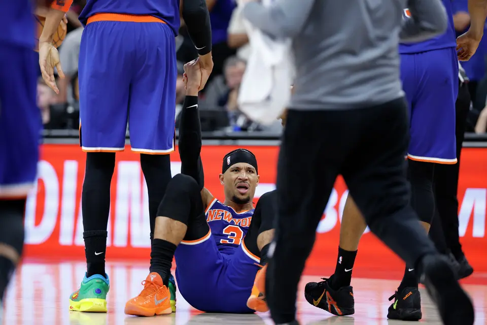 New York Knicks guard Josh Hart (3) is helped up by teammates after committing a foul during the fourth quarter of game five of the NBA Championship at Frost Bank Center on Saturday, June13, 2026.