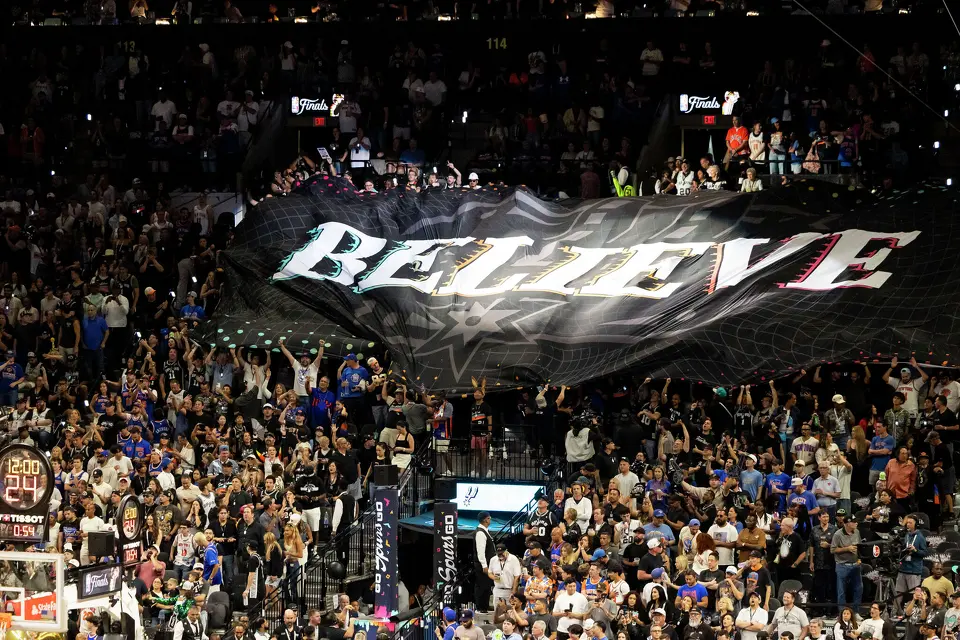 Fans wave a large flag that reads “Believe” during Game 5 of the NBA Finals at Frost Bank Center in San Antonio on Saturday, June 13, 2026.