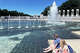Des touristes sont assis à côté d'un mémorial de la Seconde Guerre mondiale, juste à côté du Lincoln Memorial Reflecting Pool, le 16 juin 2026 à Washington, DC.