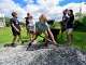 Lena Quintal, 10, a rising sixth-grader at Putney, Vt., Central School, shovels rocks into a wheelbarrow with other students as part of the school's Community Schools Initiative on Juneteenth on Friday, June 19, 2026. (Kristopher Radder /The Brattleboro Reformer via AP)