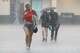 Samantha Clements of Fort Worth runs through heavy rain as she seeks shelter under the main viewing stage at FIFA Fan Festival Dallas at Fair Park on Friday, June 19, 2026, in Dallas. Fans were told to seek shelter under the main stage as lighting was detected in the area.