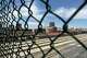 The tallest building in downtown Albuquerque, N.M., which houses the U.S. attorney's office, is seen beyond a chain link fence on Friday, June 12, 2026.