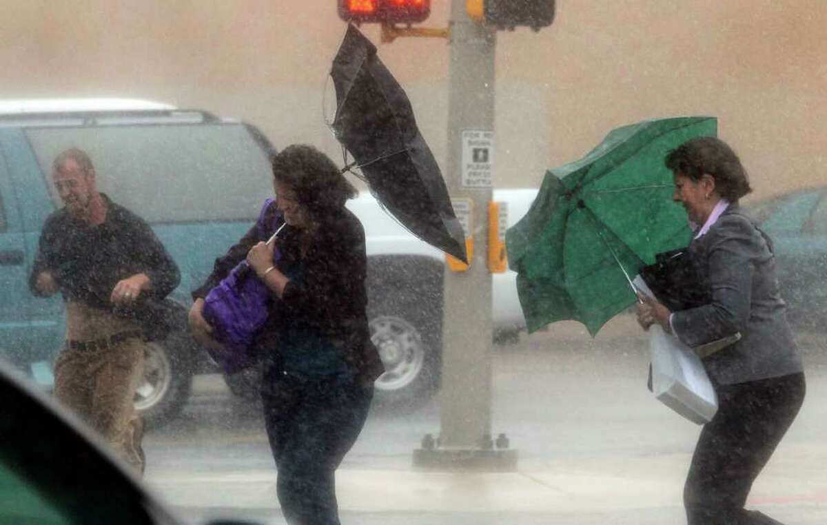 Pedestrians in downtown San Antonio near the Bexar County Justice Center battle high winds and pelting rains Tuesday September 7, 2010 as tropical storm Hermine moves through the area. JOHN DAVENPORT/jdavenport@express-news.net