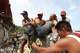 Neighbors carry a man rescued from the rubble of a collapsed building the day after earthquakes struck La Guaira, Venezuela, Thursday, June 25, 2026.