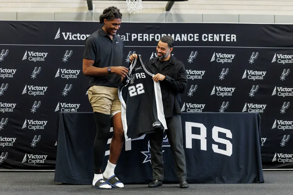 San Antonio Spurs rookie Jayden Quaintance receives a jersey from Spurs general manager Brian Wright during a news conference at Victory Capital Performance Center in San Antonio, Thursday, June 25, 2026.