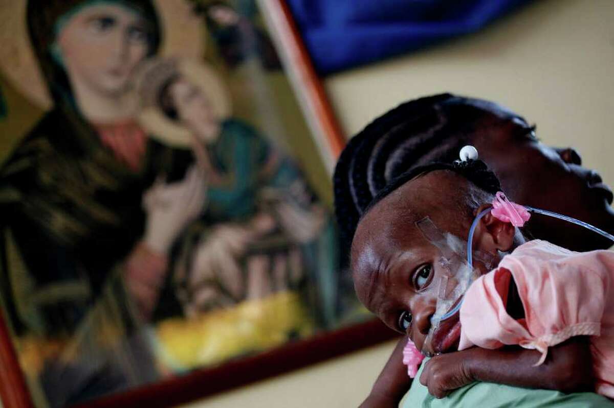 METRO - Seven-month-old Duckencia Fils-Aime rests on the shoulder of nurse Rosine Etienne at the Missionaries of Charity in Port-au-Prince, Haiti on Wednesday, March 3, 2010. LISA KRANTZ/lkrantz@express-news.net