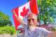 In this photo released by Dong Guangping, Dong Guangping poses for a photo with the Canadian flag after arriving in Toronto, Canada, on June 27, 2026. (Dong Guangping via AP)