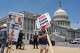 Activists endure high temperatures to protest against corruption and President Donald Trump at the Capitol in Washington, Tuesday, June 30, 2026.