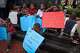Children bearing signs in support of temporary protected status for Haitians sit on the steps of the Toussaint Louverture memorial statue at the Little Haiti Cultural Complex in Miami on Jan. 12, 2026.