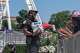 Children reach for cold bottles of water from U.S. National Park Police Officer R. Douglass as they wait in line for the ferris wheel at the Great American State Fair on the National Mall, Wednesday, July 1, 2026, in Washington.
