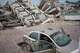 A volunteer helping remove debris from buildings damaged by the earthquakes rests on a damaged car in La Guaira, Venezuela, Friday, July 3, 2026.