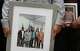 Lorenzo Salgado Jr., left, and Ronaldo Salgado, right, sons of Lorenzo Salgado Araujo, hold a family photos during a news conference in Houston Wednesday, July 8, 2026.