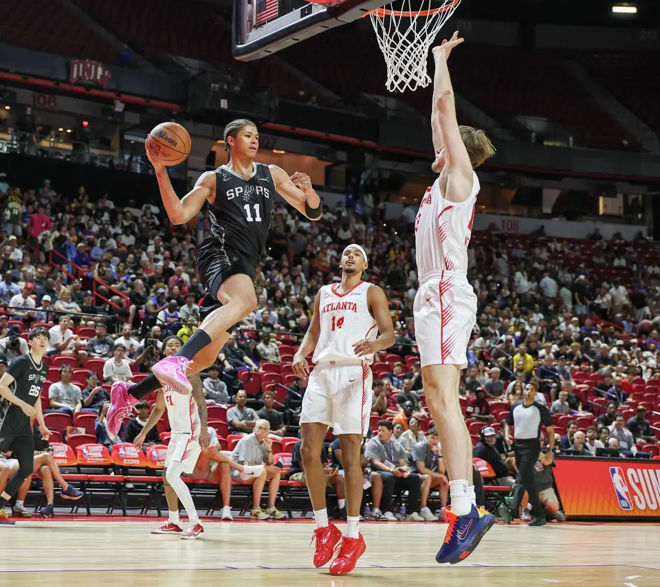 Carter Bryant #11 of the San Antonio Spurs passes against Asa Newell #14 and Henri Veesaar #13 of the Atlanta Hawks in the first half of a 2026 NBA Summer League game at the Thomas & Mack Center on July 09, 2026 in Las Vegas, Nevada.