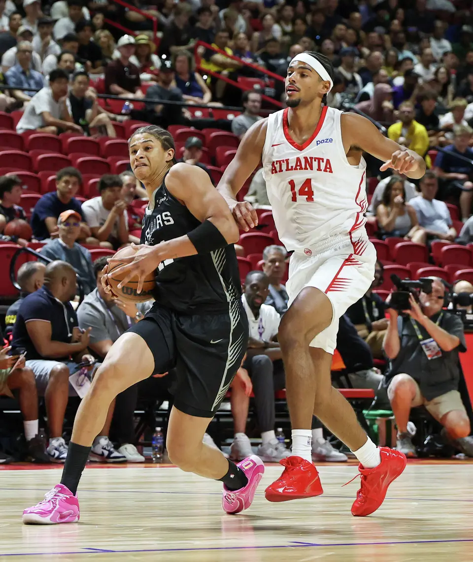 Carter Bryant #11 of the San Antonio Spurs drives against Asa Newell #14 of the Atlanta Hawks in the first half of a 2026 NBA Summer League game at the Thomas & Mack Center on July 09, 2026 in Las Vegas, Nevada.