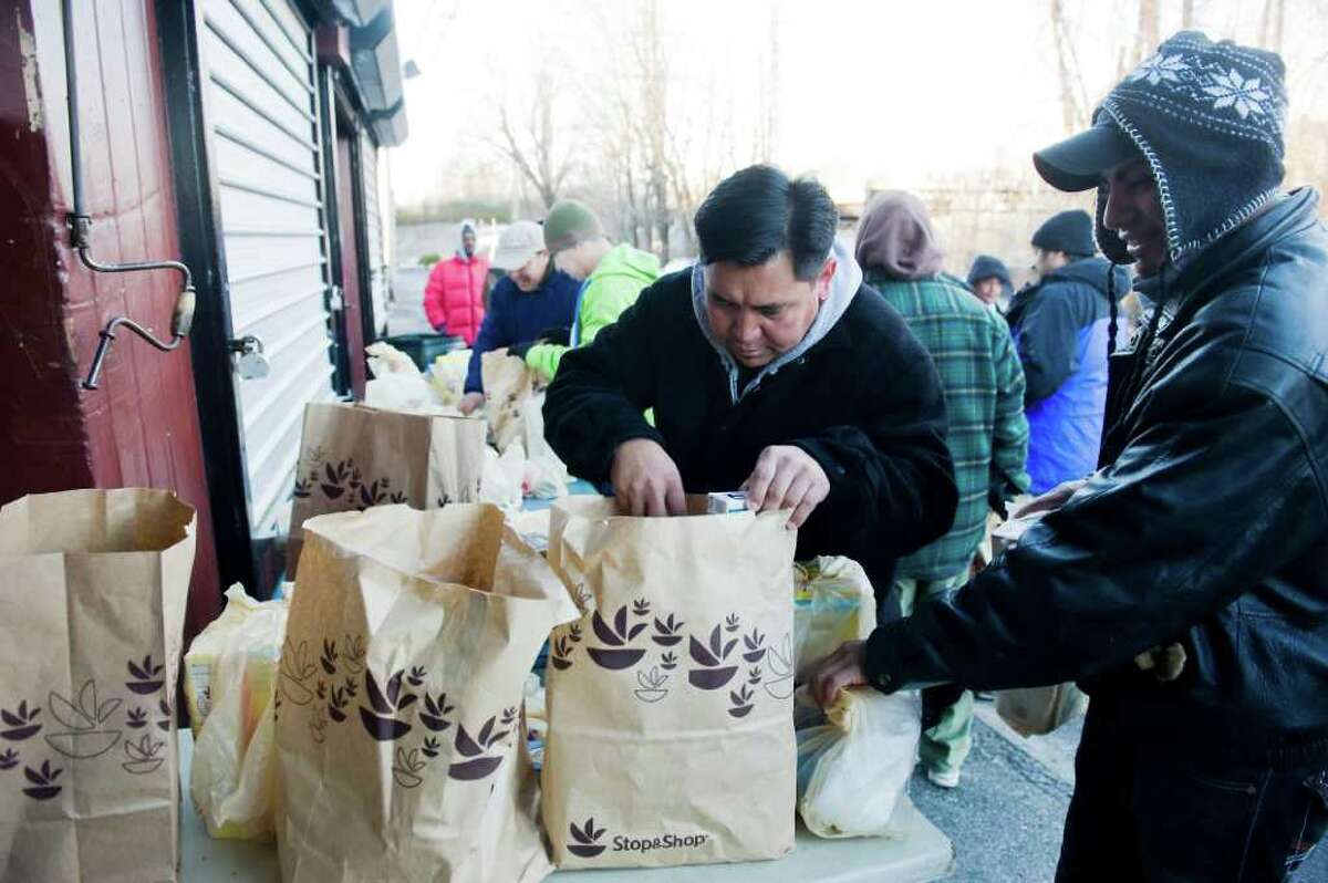 A group of day laborers receive bags of groceries from Brien McMahon students involved in the Peace Project in Norwalk, Conn on Wednesday December 22, 2010.