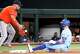 Josh Jung of the Texas Rangers is a safe with a triple ahead of the throw to Houston Astros third baseman Isaac Paredes during the first inning of a baseball game at Globe Life Field on Sunday, July 12, 2026, in Arlington.