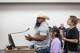 Jesse Ramos, 35, daughter Adalynn, 10, and partner Brissa Flores, 33, approach a podium and Jesse speaks out against rezoning 830 acres of farmland for a data center during a city council meeting in Red Oak, Monday, May 11, 2026.