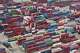 Trucks move past containers stored at a container terminal in Shanghai, China, Tuesday, July 14, 2026. (Chinatopix Via AP)