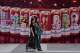 Women walk by a promotional booth displaying Budweiser beer images for the 2026 World Cup, outside a shopping mall in Beijing, China on Tuesday, July 14, 2026.
