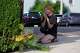 A woman prays after leaving flowers near the scene where a man was shot and killed by U.S. Immigration and Customs Enforcement on Monday, July 13, 2026, in Biddeford, Maine.