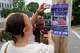 Angeliki Cintron, left, and Saidi Moseley post a notice of an upcoming gathering in response to the recent killings by U.S. Immigration and Customs Enforcement agents, in Biddeford, Maine, Wednesday, July 15 2026.