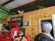 Rich Diesel Repair employee Ryan Hess looks up at a cat named Bucket in Center Point on Thursday, July 16, 2026. Hess said Bucket scampered to the elevated ledge as floodwater rose inside the shop.
