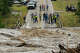 People gather to watch as the Perdenales River floods Ranch Road 1623 in Stonewall, Thursday, July 16, 2026.