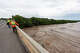 U.S. Geological Survey employees use a device to measure how fast the water moves as they stand above the Pedenales River in Johnson City, Thursday, July 16, 2026.