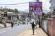 FILE - A woman walks past a billboard promoting the Safe Motherhood Bill on Wilkinson Road in Freetown, Sierra Leone, March 12, 2025.