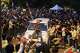 A protestor sits on the hood of a police car during a demonstration demanding educational reforms as part of the Cockroach Janta Party's ongoing protest movement in New Delhi, India, Wednesday, July 22, 2026.