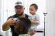 Jack Chang cuts Isaac Obamehinti's hair while holding his 2-year-old son Cairo Miu at his studio on Monday, July 13, 2026, in San Francisco.