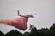 A De Havilland Canada DHC-8-400 Dash 8 operated by the French civil defense agency drops fire retardant as wildfires rage near Marcheprime, outside Bordeaux, France, Monday, July 27, 2026.