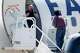 A man calls to someone on the ground as a man in restraints boards an Eastern Air Express plane at Dallas Love Field on Tuesday, July 28, 2026, in Dallas.